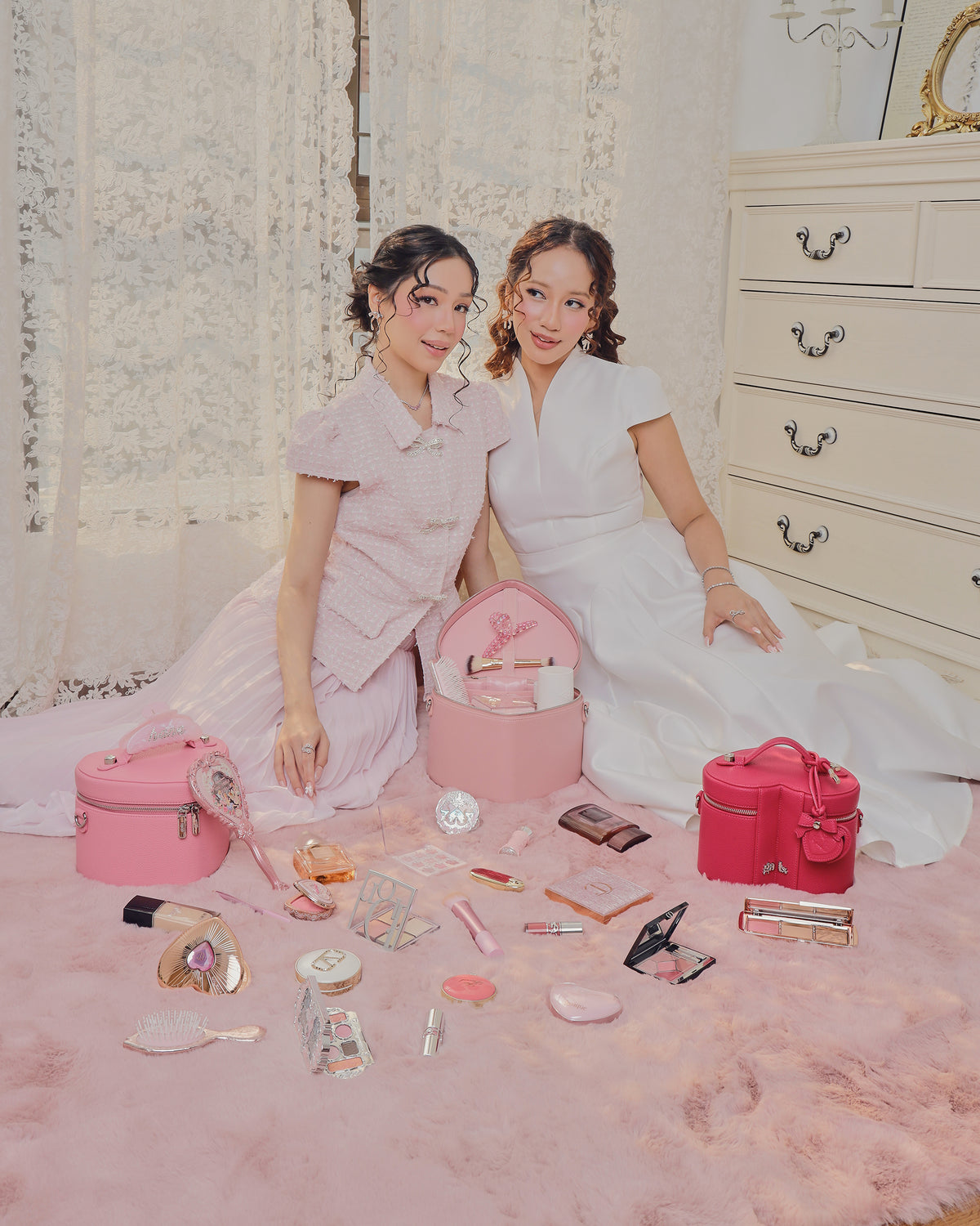 GALS Lovette Vanity campaign with two women, pink vanity cases and makeup arranged on a pink rug
